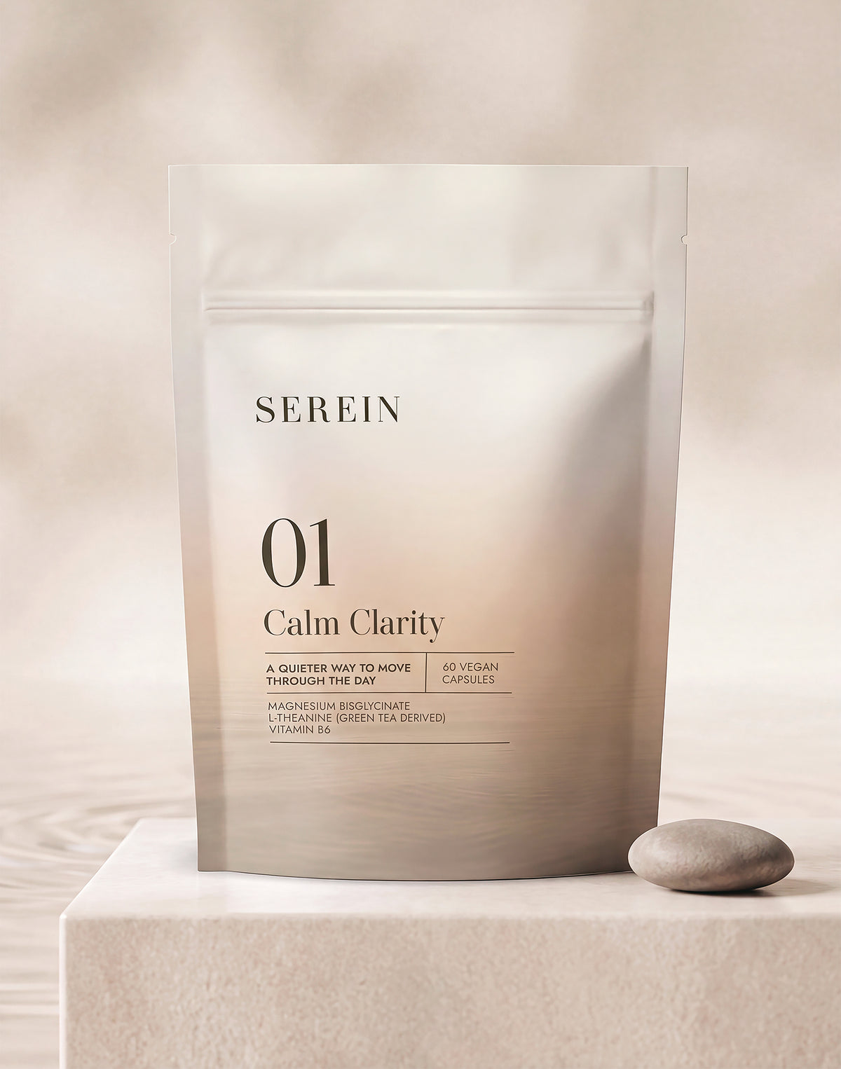 SEREIN No.1 Calm Clarity supplement pouch displayed on a light stone plinth beside a smooth pebble in soft natural light